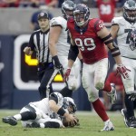Philadelphia Eagles quarterback Mark Sanchez, left, slowly gets up after being sacked 7-yard loss by Houston Texans defensive end J.J. Watt, right, during the second quarter of an NFL football game, Sunday, Nov. 2, 2014, in Houston. (AP Photo/Patric Schneider)