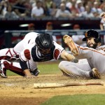 San Francisco Giants' Ryan Vogelsong scores on a sacrifice fly by teammate Joe Panik around the tag of Arizona Diamondbacks catcher Tuffy Gosewisch, left, during the fifth inning of a MLB baseball game, Tuesday, April 7, 2015, in Phoenix. (AP Photo/Matt York)
