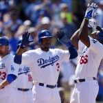 Los Angeles Dodgers' Yasiel Puig, right, points to the sky as Carl Crawford, center, and Adrian Gonzalez look on after hitting a three-run home run during the sixth inning of a baseball game against the Arizona Diamondbacks, Sunday, April 20, 2014, in Los Angeles. (AP Photo/Mark J. Terrill)