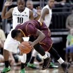 Arizona State guard Jahii Carson, right, loses his balance driving against Oregon guard Johnathan Loyd during the first half of an NCAA college basketball game in Eugene, Ore., Tuesday, March 4, 2014. (AP Photo/Don Ryan)