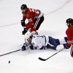 Tampa Bay Lightning's Brian Boyle, center, tries to reach a loose puck as he falls between Chicago Blackhawks' Bryan Bickell (29) and Duncan Keith during the second period in Game 3 of the NHL hockey Stanley Cup Final on Monday, June 8, 2015, in Chicago. (AP Photo/Charles Rex Arbogast)