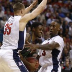 Oregon's Elgin Cook, center, is defended by Arizona's Kaleb Tarczewski, left, and Arizona's Rondae Hollis-Jefferson during the first half of an NCAA college basketball game in the championship of the Pac-12 conference tournament Saturday, March 14, 2015, in Las Vegas. (AP Photo/John Locher)
