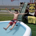 Collin Heilman, 11, of Ormond Beach, Fla. slides in a pool of water in the infield at Daytona International Speedway prior to a NASCAR Xfinity series auto race, Saturday, July 4, 2015, in Daytona Beach, Fla. (AP Photo/Phelan M. Ebenhack)
