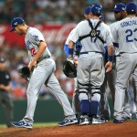 The Dodgers' starting pitcher Clayton Kershaw, left, is pulled from the Major League Baseball opening game between the Los Angeles Dodgers and Arizona Diamondbacks at the Sydney Cricket ground in Sydney, Saturday, March 22, 2014. (AP Photo/Rick Rycroft)