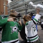 Chris Churchman, left, of Fort Worth, Texas, walks in front of American Airlines Center with his brother Alex Churchman, right, of Rowlette, Texas, motivating fans before a first-round NHL hockey Stanley Cup playoff series game against the Anaheim Ducks, Monday, April 21, 2014, in Dallas. (AP Photo/Tony Gutierrez)
