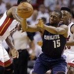 Charlotte Bobcats' Kemba Walker (15) passes the ball as Miami Heat's Norris Cole, right, and another player defend during the first half in Game 2 of an opening-round NBA basketball playoff series, Wednesday, April 23, 2014, in Miami. (AP Photo/Lynne Sladky)