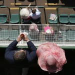Fans wait for a race to start before the 141th running of the Kentucky Oaks horse race at Churchill Downs Friday, May 1, 2015, in Louisville, Ky. (AP Photo/Charlie Riedel)