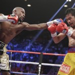 Floyd Mayweather Jr., left, stops Manny Pacquiao, from the Philippines, with a left during their welterweight title fight on Saturday, May 2, 2015 in Las Vegas. (AP Photo/Isaac Brekken)