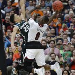 Michigan State's Travis Trice (20) defends Louisville's Terry Rozier (0) during the second half of a regional final in the NCAA men's college basketball tournament Sunday, March 29, 2015, in Syracuse, N.Y. (AP Photo/Seth Wenig)