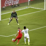 United States' Clint Dempsey, bottom left, scores the opening goal past Ghana's goalkeeper Adam Kwarasey, top, during the group G World Cup soccer match between Ghana and the United States at the Arena das Dunas in Natal, Brazil, Monday, June 16, 2014. (AP Photo/Hassan Ammar)