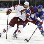 Arizona Coyotes' Lucas Lessio (38) and New York Rangers' Kevin Klein (8) fight for control of the puck during the first period of an NHL hockey game Thursday, Feb. 26, 2015, in New York. (AP Photo/Frank Franklin II)