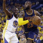 Cleveland Cavaliers forward LeBron James, right, drives on Golden State Warriors forward Draymond Green during the first half of Game 5 of basketball's NBA Finals in Oakland, Calif., Sunday, June 14, 2015. (AP Photo/Ben Margot)
