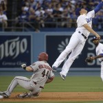 Arizona Diamondbacks' Paul Goldschmidt, left, steals second base as Los Angeles Dodgers shortstop Enrique Hernandez leaps to catch a wild throw during the first inning of a baseball game, Tuesday, June 9, 2015, in Los Angeles. (AP Photo/Jae C. Hong)