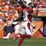 Arizona Cardinals wide receiver Larry Fitzgerald (11) pulls down a catch as Denver Broncos cornerback Aqib Talib (21) defends during the first half of an NFL football game, Sunday, Oct. 5, 2014, in Denver. (AP Photo/Jack Dempsey)