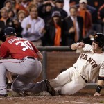 San Francisco Giants' Buster Posey is tagged out at home by Washington Nationals pitcher Aaron Barrett (30) after he ran on a wild pitch in the seventh inning during Game 4 of baseball's NL Division Series in San Francisco, Tuesday, Oct. 7, 2014. (AP Photo/Marcio Jose Sanchez)