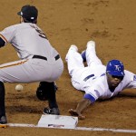 Kansas City Royals' Lorenzo Cain slides safely back to first with San Francisco Giants' Brandon Belt covering during the first inning of Game 6 of baseball's World Series Tuesday, Oct. 28, 2014, in Kansas City, Mo. (AP Photo/Jeff Roberson)
