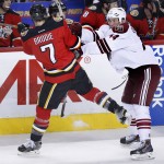 Arizona Coyotes' B.J. Crombeen, right, hits Calgary Flames' TJ Brodie during the second period of an NHL hockey game, Tuesday, April 7, 2015 in Calgary, Alberta. (AP Photo/The Canadian Press, Larry MacDougal)