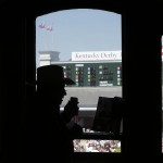 A fan looks over a program before the 141th running of the Kentucky Oaks horse race at Churchill Downs Friday, May 1, 2015, in Louisville, Ky. (AP Photo/Charlie Riedel)