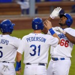 Los Angeles Dodgers' Yasiel Puig, right, gestures in front of Alberto Callaspo, left, and Joc Pederson as he scores after hitting a three-run home run during the second inning of a baseball game against the Arizona Diamondbacks, Wednesday, June 10, 2015, in Los Angeles. (AP Photo/Mark J. Terrill)