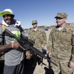 Staff Sgt. Zachary Holschuh, right, shows Arizona Cardinals Antonio Cromartie a rifle after a practice session at Luke Air Force Base for the NFL Football Pro Bowl Thursday, Jan. 22, 2015, in Glendale, Ariz. (AP Photo/David J. Phillip)