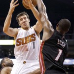 Phoenix Suns' Goran Dragic, left, of Slovenia, gets the ball tipped away by Miami Heat's Chris Bosh, right, during the second half of an NBA basketball game Tuesday, Dec. 9, 2014, in Phoenix. The Heat won 103-97. (AP Photo/Ross D. Franklin)