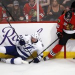 Tampa Bay Lightning's Anton Stralman, of Sweden, falls as he chases after a loose puck along the boards with Chicago Blackhawks' Antoine Vermette, right, during the second period in Game 6 of the NHL hockey Stanley Cup Final series on Monday, June 15, 2015, in Chicago. (AP Photo/Charles Rex Arbogast)