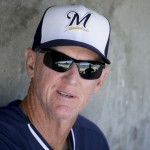 Milwaukee Brewers manager Ron Roenicke sits in the dugout before a spring exhibition baseball game against the Arizona Diamondbacks in Scottsdale, Ariz., Sunday, March 16, 2014. (AP Photo/Chris Carlson)