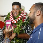 Former Oregon quarterback Marcus Mariota, center, shares a laugh with his high school football coach Darnell Arceneaux, right, while looking at a selfie picture at the Saint Louis Alumni Clubhouse on NFL Draft Day Thursday, April 30, 2015, in Honolulu. (Thomas Boyd/The Oregonian via AP, Pool)