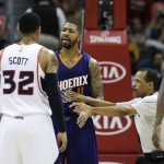 Referee Eric Lewis separates Atlanta Hawks' Mike Scott, left, and Phoenix Suns' Markieff Morris as they exchange words in the second quarter of an NBA basketball game Tuesday, April 7, 2015, in Atlanta. Scott was called for a technical foul on the play. (AP Photo/David Goldman)