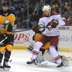 Buffalo Sabres defenseman Zach Bogosian, left, blocks a shot while Arizona Coyotes right wing David Moss (18) looks for a rebound during the second period of an NHL hockey game Thursday, March 26, 2015, in Buffalo, N.Y. (AP Photo/Gary Wiepert)