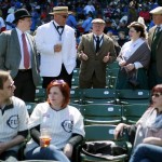 Baseball fans dress in period clothes, top, and the replica 1914 Chicago Federals jersey, bottom left, at the 100th anniversary of the first baseball game at Wrigley Field, before a game between the Arizona Diamondbacks and Chicago Cubs, Wednesday, April 23, 2014, in Chicago. (AP Photo/Charles Rex Arbogast)
