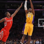 Los Angeles Lakers guard Kobe Bryant, right, puts up a shot as Houston Rockets guard Trevor Ariza defends during the first half of an NBA basketball game, Tuesday, Oct. 28, 2014, in Los Angeles. (AP Photo/Mark J. Terrill)