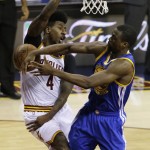 Cleveland Cavaliers guard Iman Shumpert (4) is fouled by Golden State Warriors forward Harrison Barnes (40) during the first half of Game 6 of basketball's NBA Finals in Cleveland, Tuesday, June 16, 2015. (AP Photo/Darron Cummings)
