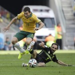 Spain's Juanfran tries to tackle Australia's Tommy Oar during the group B World Cup soccer match between Australia and Spain at the Arena da Baixada in Curitiba, Brazil, Monday, June 23, 2014. (AP Photo/Fernando Vergara)