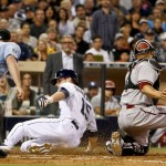 San Diego Padres' Cory Spangenberg is safe sliding into home and scoring as Arizona Diamondbacks catcher Welington Castillo is late with the tag after a sacrifice fly by Matt Kemp during the fifth inning of a baseball game Friday, June 26, 2015, in San Diego. The umpire is Quinn Wolcott. (AP Photo/Lenny Ignelzi)
