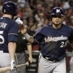 Milwaukee Brewers' Gerardo Parra, right, slaps hands with Shane Peterson (35) after Parra scored a run on a wild pitch by the Arizona Diamondbacks during the ninth inning of a baseball game Friday, July 24, 2015, in Phoenix. The Brewers defeated the Diamondbacks 2-1. (AP Photo/Ross D. Franklin)