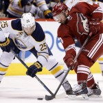 Buffalo Sabres' Mikhail Grigorenko (25), of Russia, battles Arizona Coyotes' Sam Gagner (9) for the puck after a face-off during the first period of an NHL hockey game Monday, March 30, 2015, in Glendale, Ariz. (AP Photo/Ross D. Franklin)