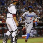 Los Angeles Dodgers' Jimmy Rollins scores on a base hit by Howie Kendrick during the seventh inning of a baseball game, as Arizona Diamondbacks catcher Welington Castillo looks on, Tuesday, June 30, 2015, in Phoenix. (AP Photo/Matt York)
