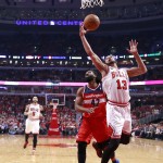 Chicago Bulls center Joakim Noah (13) grabs a rebound over Washington Wizards forward Nene Hilario (42) during the first half of Game 2 in an opening-round NBA basketball playoff series Tuesday, April 22, 2014, in Chicago. (AP Photo/Charles Rex Arbogast)
