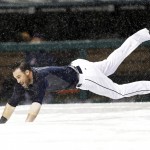 Cleveland Indians' Jason Kipnis slides on the tarp after the baseball game between the Indians and the Arizona Diamondbacks was postponed, Tuesday, Aug. 12, 2014, in Cleveland. (AP Photo/Tony Dejak)