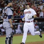 Arizona Diamondbacks' Paul Goldschmidt scores on a base hit by Mark Trumbo as Detroit Tigers catcher Bryan Holaday looks on during the fourth inning of a baseball game, Monday, July 21, 2014, in Phoenix. (AP Photo/Matt York)