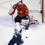 Tampa Bay Lightning's Cedric Paquette, bottom, tries to get off a shot as Chicago Blackhawks goalie Corey Crawford defends during the first period in Game 6 of the NHL hockey Stanley Cup Final series on Monday, June 15, 2015, in Chicago. (AP Photo/Charles Rex Arbogast)