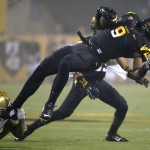 Arizona State running back Kalen Ballage (9) is tripped up by UCLA defensive back Fabian Moreau during the first half of an NCAA college football game, Thursday, Sept. 25, 2014, in Tempe, Ariz. (AP Photo/Matt York)
