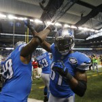Detroit Lions wide receiver Calvin Johnson (81) greets teammate defensive tackle C.J. Mosley (99) before the first half of an NFL football game against the Chicago Bears in Detroit, Thursday, Nov. 27, 2014. (AP Photo/Paul Sancya)