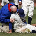 Chicago Cubs right fielder Justin Ruggiano is tended to during the ninth inning of a baseball game against the Arizona Diamondbacks at Wrigley Field in Chicago on Wednesday, April 23, 2014. (AP Photo/Andrew A. Nelles)