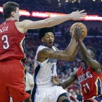 Orlando Magic guard Elfrid Payton (4) drives to the basket between New Orleans Pelicans center Omer Asik (3) and guard Jrue Holiday (11) in the first half of an NBA basketball game in New Orleans, Tuesday, Oct. 28, 2014. (AP Photo/Gerald Herbert)