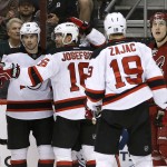 New Jersey Devils' Adam Henrique, second from left, celebrates his goal with teammates Damon Severson (28), Jacob Josefson (16), of Sweden, and Travis Zajac (19) as Arizona Coyotes' Michael Stone (26) looks away during the second period of an NHL hockey game Saturday, March 14, 2015, in Glendale, Ariz. (AP Photo/Ross D. Franklin)