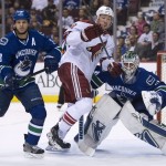 Vancouver Canucks defenseman Kevin Bieksa (3) tries to clear Arizona Coyotes right wing David Moss (18) from in front of Canucks goalie Eddie Lack (31 during the first period of an NHL hockey game Thursday, April 9, 2015, in Vancouver, British Columbia. (AP Photo/The Canadian Press, Jonathan Hayward)