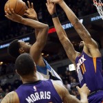 Phoenix Suns' Markieff Morris, right, tries to block a shot by Minnesota Timberwolves' Andrew Wiggins during the second half of an NBA basketball game, Friday, Feb. 20, 2015, in Minneapolis. The Timberwolves won 111-109.. (AP Photo/Jim Mone)