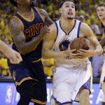 Golden State Warriors guard Klay Thompson, right, shoots against Cleveland Cavaliers guard J.R. Smith during the second half of Game 1 of basketball's NBA Finals in Oakland, Calif., Thursday, June 4, 2015. (AP Photo/Ben Margot)